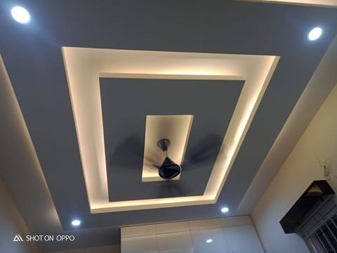 False ceiling with unique patterns, textures, and shapes, enhancing the overall ambiance of the living room designed by the best interior designers in hyderabad