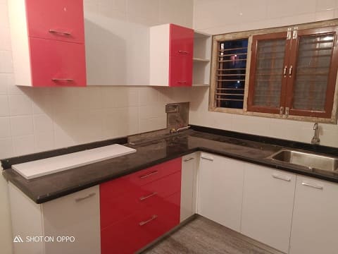 pink and white cabinets used for this l shaped kitchen to make it dainty and cozy for our clients designed by the budgeted interior designers in hyderabad