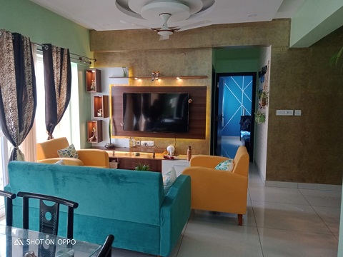 carefully placed accent chairs, the artful arrangement of lighting fixtures,and the harmonious fusion of teal and peach has been carefully curated as per the residents choice